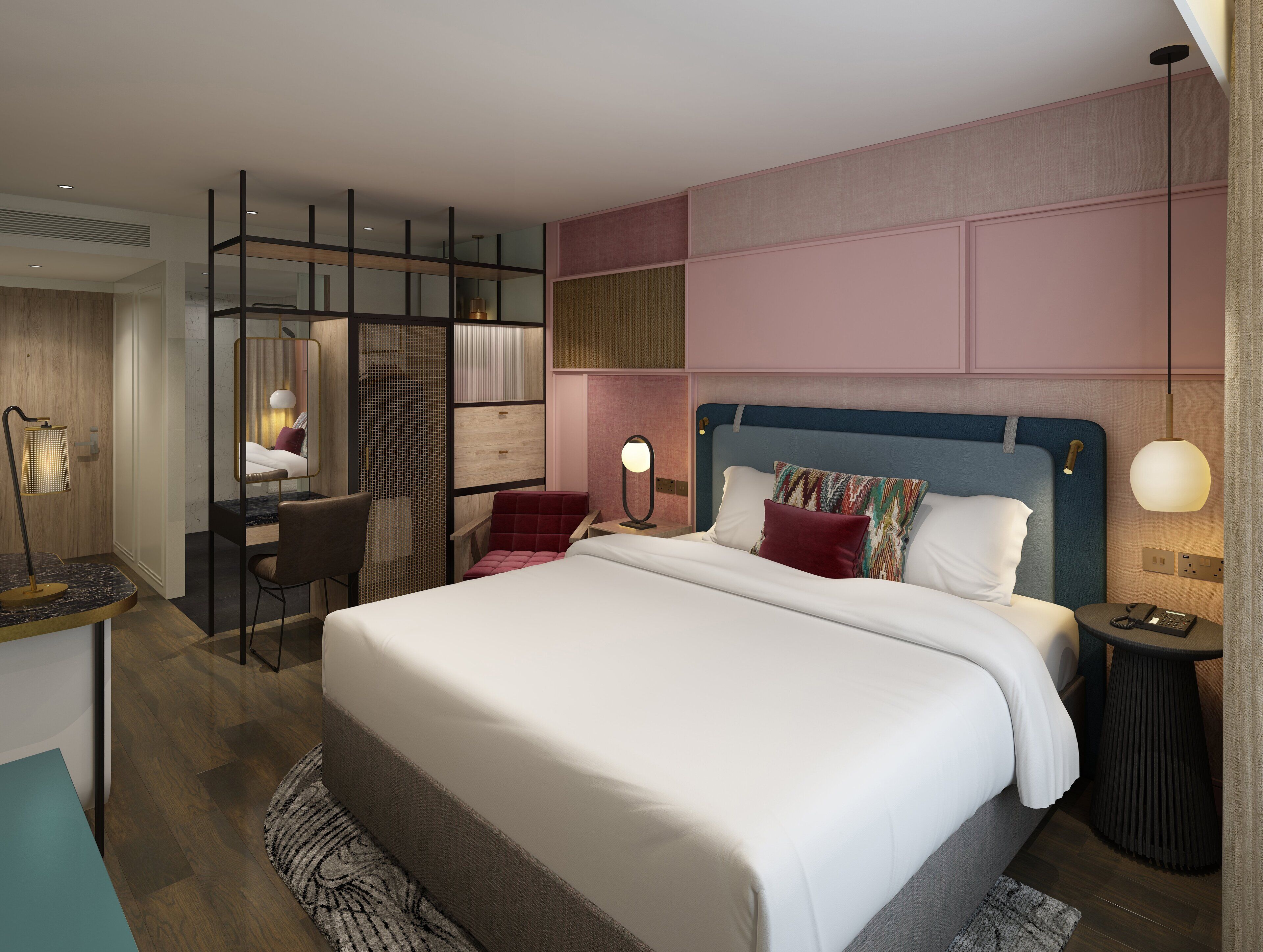 A modern hotel room with a large bed, a desk, a chair, and a small table.