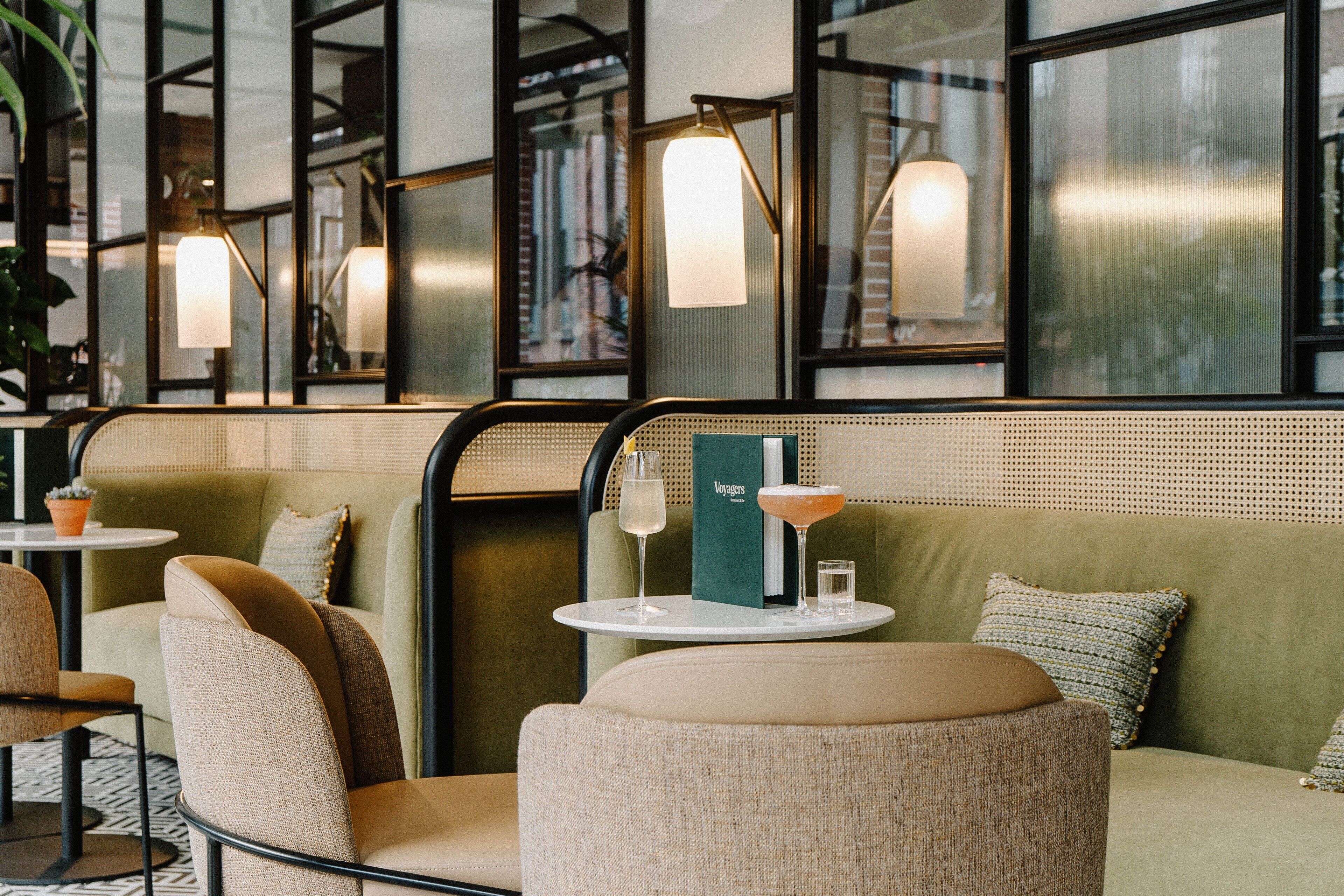 A modern interior with seating areas, tables, and decorative lighting.