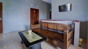 Une pièce avec un banc en bois, une table en marbre et une porte portant le numéro 6.