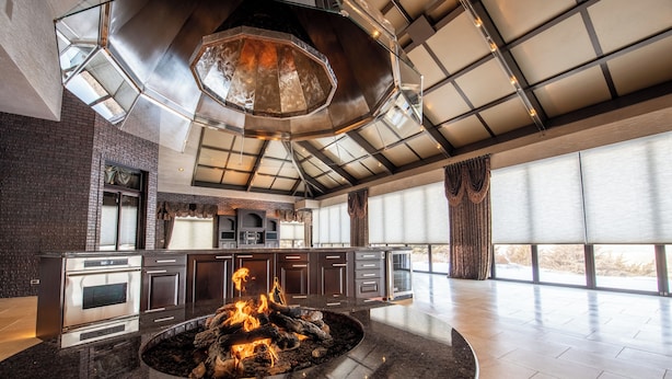 A spacious kitchen with a central fire feature, modern cabinetry, and large windows. - Valley View Villa - Event Venue/Pheasant Hunting/Sleeps 18/9 Beds/6.5 Bath (Mitchell)