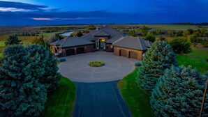 A large house with a driveway leading to a garage, surrounded by trees and fields. - Valley View Villa - Event Venue/Pheasant Hunting/Sleeps 18/9 Beds/6.5 Bath (Mitchell)