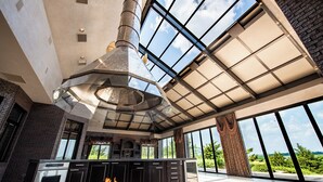 A spacious kitchen with a central island, large windows, and a high ceiling. - Valley View Villa - Event Venue/Pheasant Hunting/Sleeps 18/9 Beds/6.5 Bath (Mitchell)