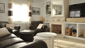 A living room with a leather sofa, a white coffee table, a fireplace, and a television. - Luxe 6P Kindervriendelijke Villa met Zwembad, Airco, Internet Wifi, Alarm en BBQ (Mazarrón)