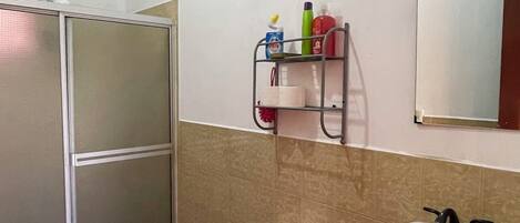 Une salle de bain comprenant des toilettes, un lavabo et un espace douche.