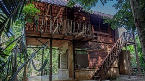 Une maison en bois dotée d’un balcon et d’un escalier menant à l’étage supérieur.