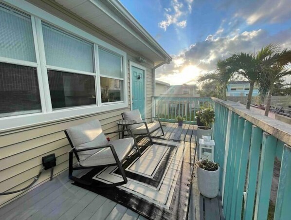 Relax on the deck with a comfortable seating area and lush surroundings.