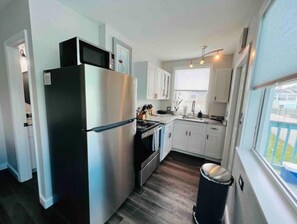 Kitchen features a stainless steel refrigerator, oven, and white cabinetry.