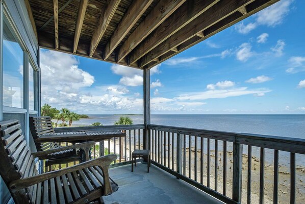 A wooden deck with a view of the ocean and beach.