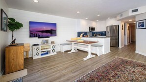 A modern kitchen with white cabinetry, a stainless steel refrigerator, and a built-in oven. - Fenimore Mill 1C - Pool and Beautiful Gulf Views! (Cedar Key)