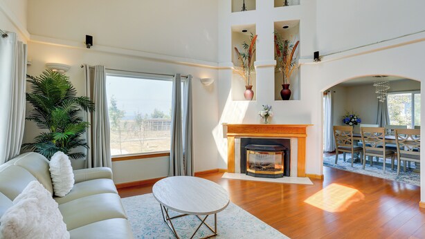 Amplia sala de estar con chimenea, un sofá y un comedor.
