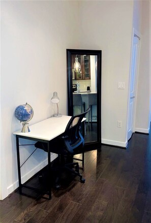 A small office space with a desk, chair, globe, and lamp. - The Luxe | City View | Romantic Escape (Atlanta)