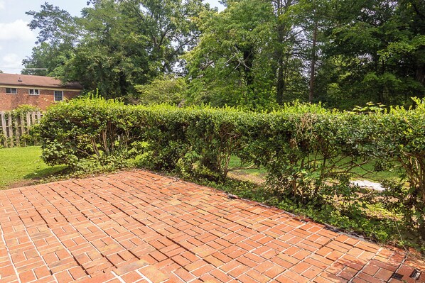 A brick patio with a neatly trimmed hedge in the foreground. - Walkable to UVA, and Fontaine Research park, Newly Renovated Home. (Charlottesville)