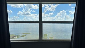 A room with a large window overlooking a body of water and a clear sky. - 2 Bed/2 Bath Condo - Close to Downtown Sebring & Racetrack (Sebring)