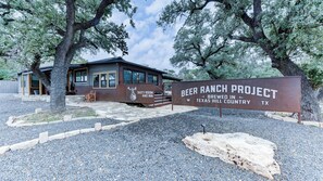 A rustic building with a sign reading "Beer Ranch Project Brewed in Texas Hill Country, TX." - Studio 1 at Beer Ranch Project. Walk to Wimberley Square. Unwind. Stay awhile. (Wimberley)