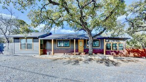 A single-story house with a front porch, a garage, and a small driveway. - Studio 1 at Beer Ranch Project. Walk to Wimberley Square. Unwind. Stay awhile. (Wimberley)