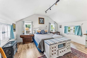 Un dormitorio con cama, cómoda, mesita de noche, ventana y radiador.