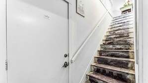 Una escalera con una puerta blanca y una barandilla de metal.