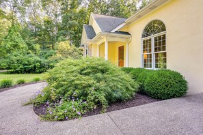 A yellow house with a covered porch and a large arched window. - Charming Flushing Cottage w/ Deck + Spacious Yard! (Flushing)