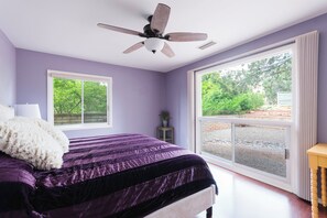 A bedroom with a large bed, a ceiling fan, and a view of the outdoors through a sliding glass door. - Johnny Guitar Getaway, Discover the allure of West Sedona!! (Sedona)