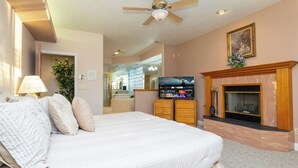A bedroom with a bed, a television, a fireplace, and a ceiling fan. - Bullhead City Riverfront Home with Dock! (Bullhead City)