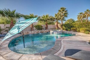 Una piscina al aire libre, sombrillas, sillones reclinables de piscina