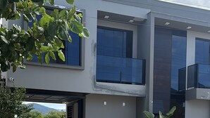 Un bâtiment moderne à deux étages, doté d’un toit plat, de grandes fenêtres et d’une allée gravillonnée.