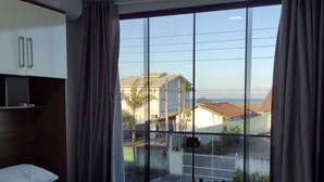 Une chambre dotée d’un grand lit, d’une armoire et d’une porte-fenêtre coulissante donnant sur un balcon.