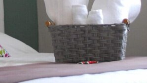 A wicker basket with white towels on a bed. - Outstanding Loft AC, WiFi 60MB, Kitchen, Bathroom
 (Cancún)