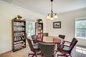 A conference room with a large table, six chairs, and two bookshelves filled with books and games. - Semora Vacation Rental w/ Dock on Hyco Lake! (Semora)