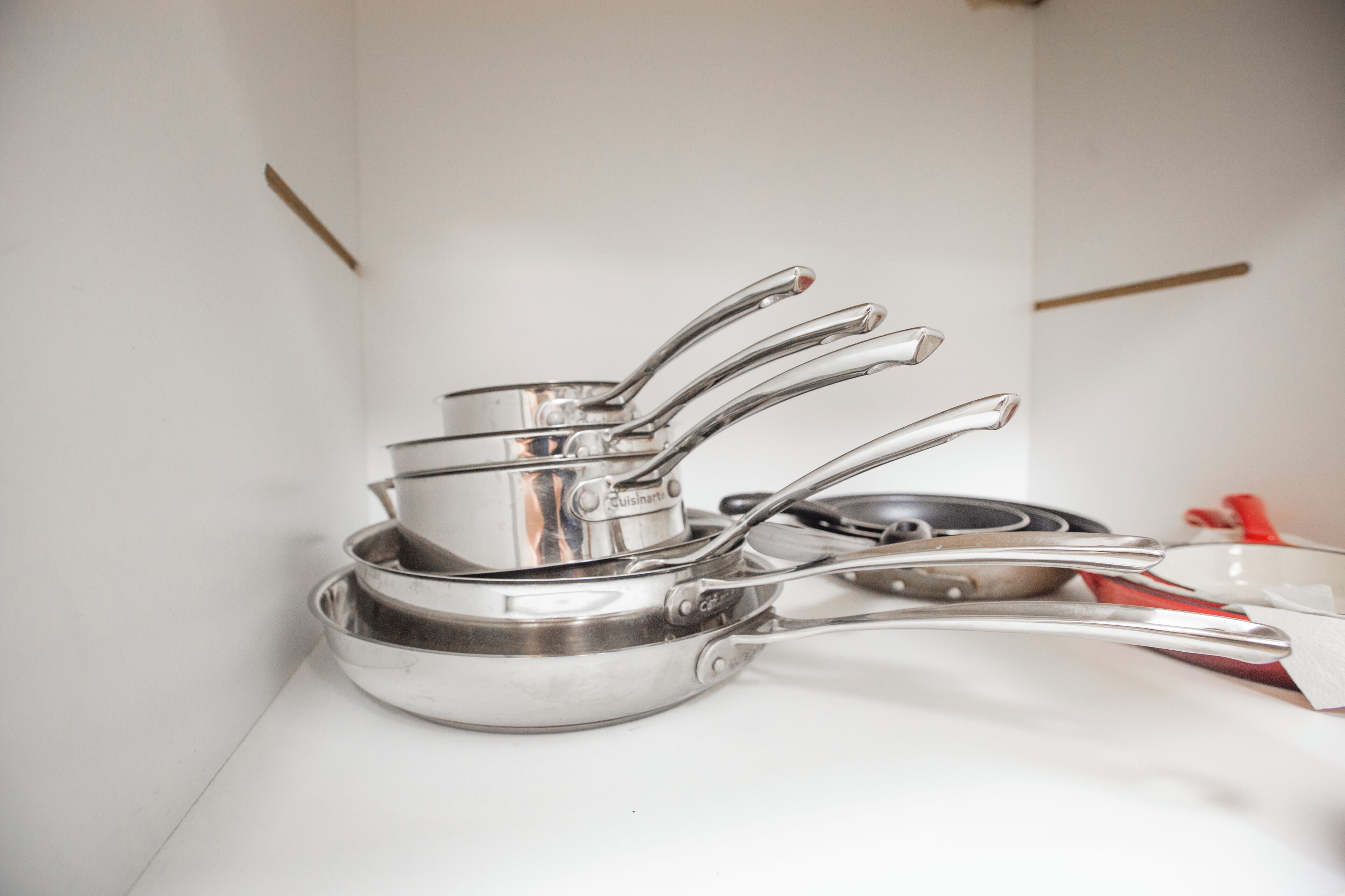 A kitchen with stainless steel cookware and utensils.