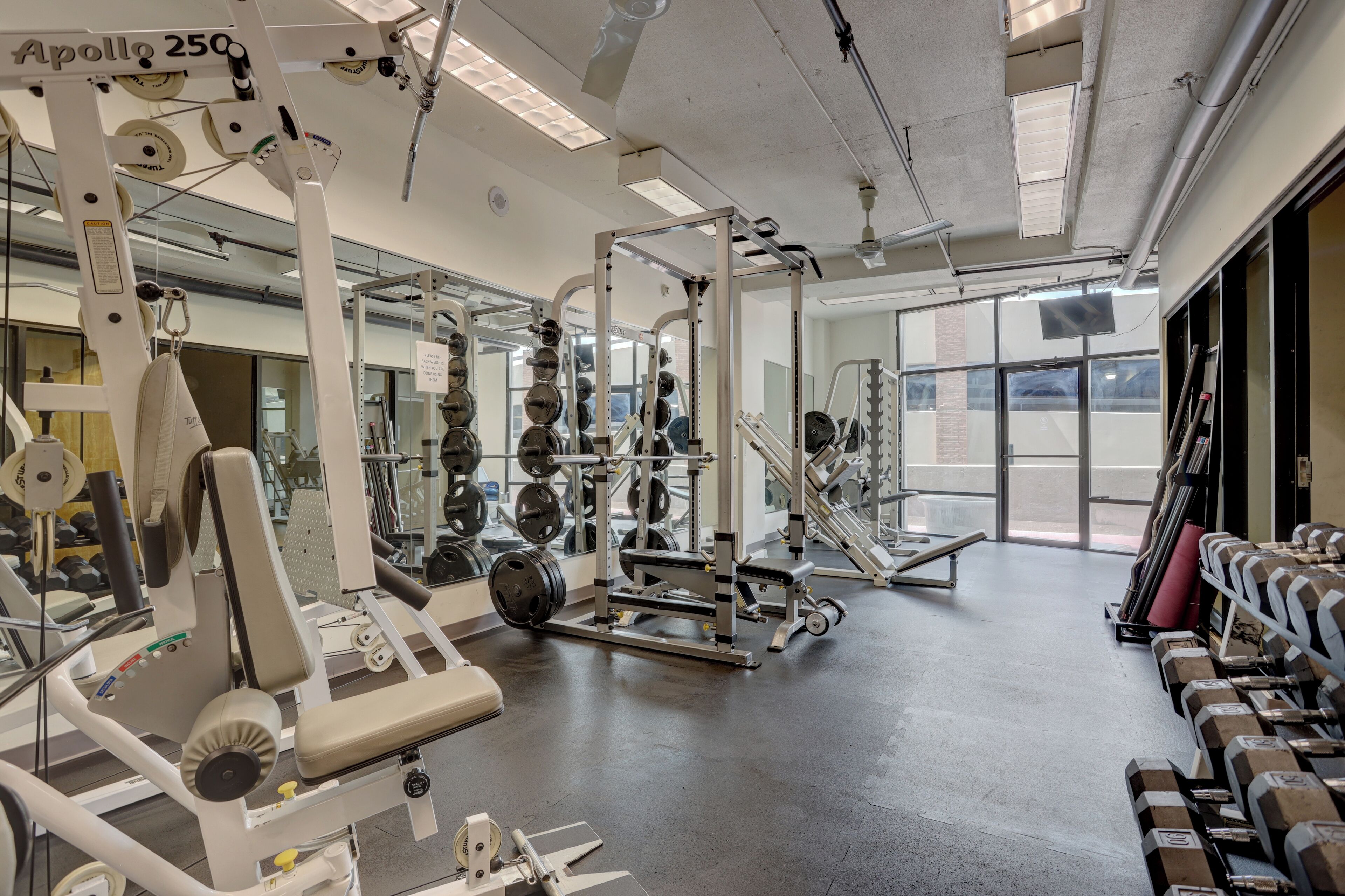 A gym with various exercise equipment, including weight machines and free weights.