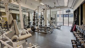 Une salle de sport équipée de divers appareils d’entraînement, notamment des machines à poids et des poids libres.