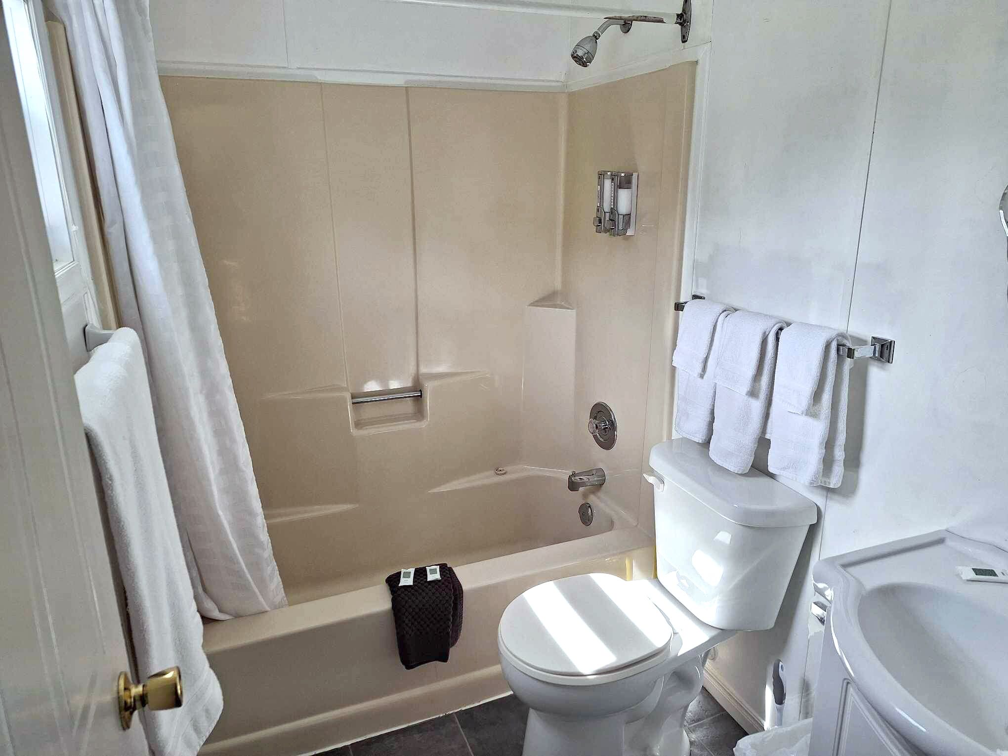 A bathroom with a bathtub, toilet, and sink.