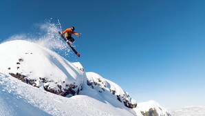 A snowboarder performing a jump over a snow-covered mountain. - Northern  Twin  Room (Norden)