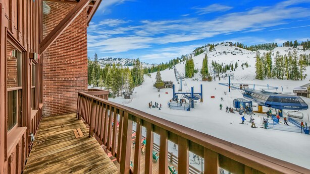 A wooden balcony overlooking a ski resort with a ski lift and snow-covered slopes. - Deluxe  Suite   Room (Norden)