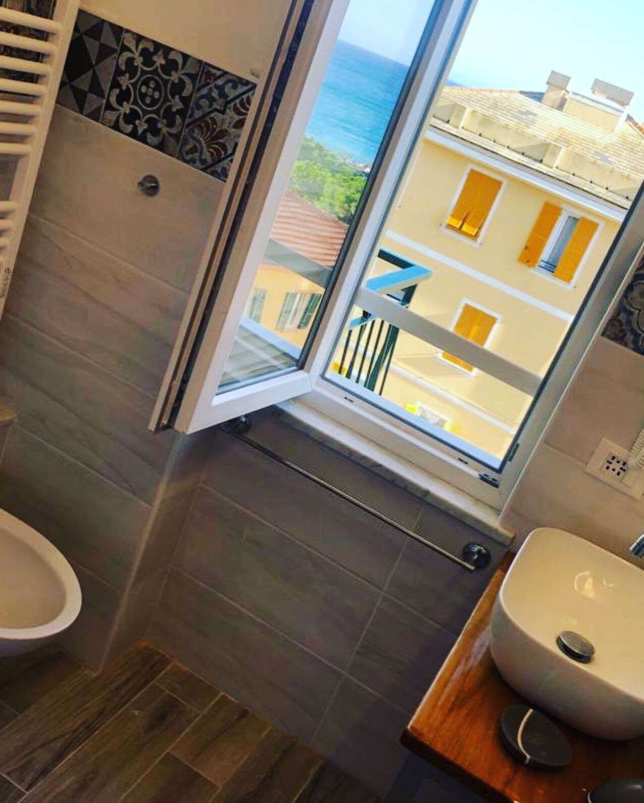 A bathroom with a window, a toilet, and a sink.