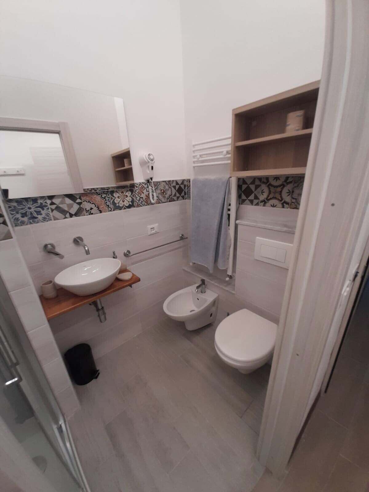 A compact bathroom with a white sink, bidet, and toilet.