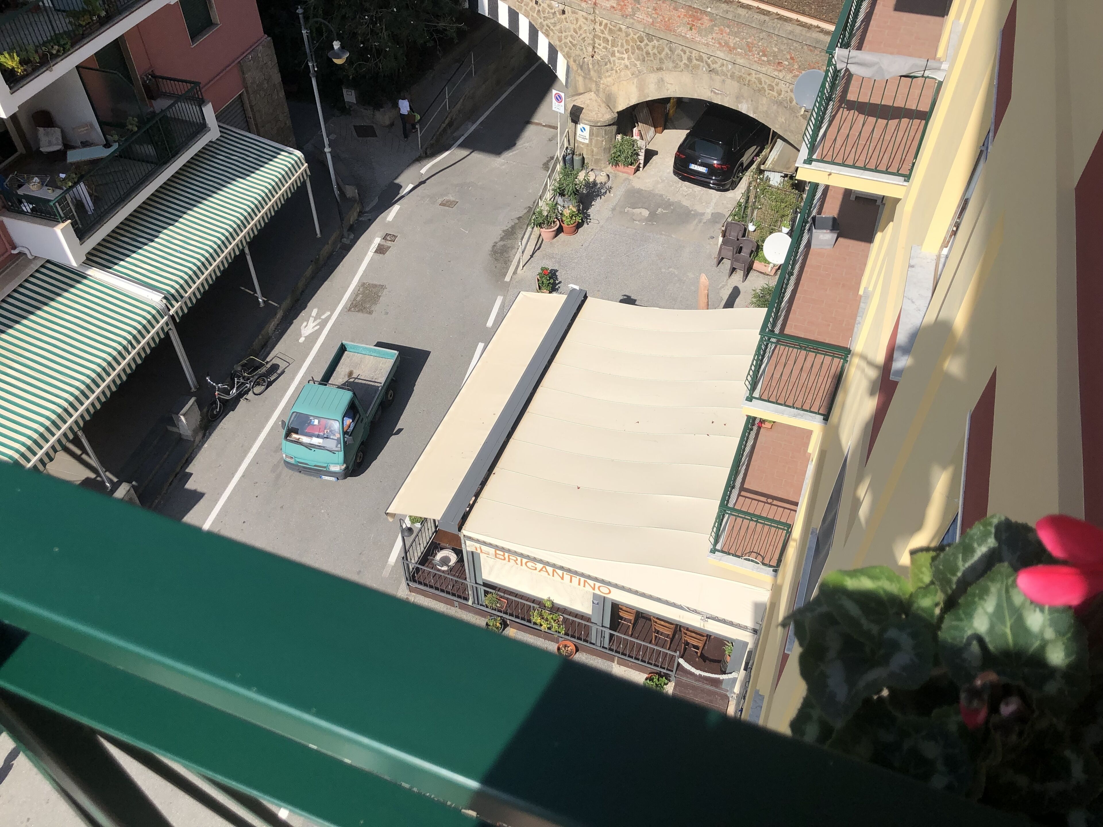 A street view with a building featuring a flat roof and a sign that reads "BRIGANTINO".