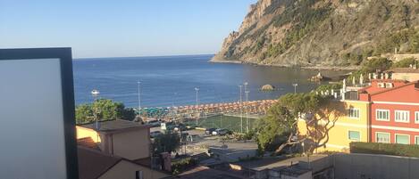Un pueblo costero con edificios, una montaña y vista al mar.