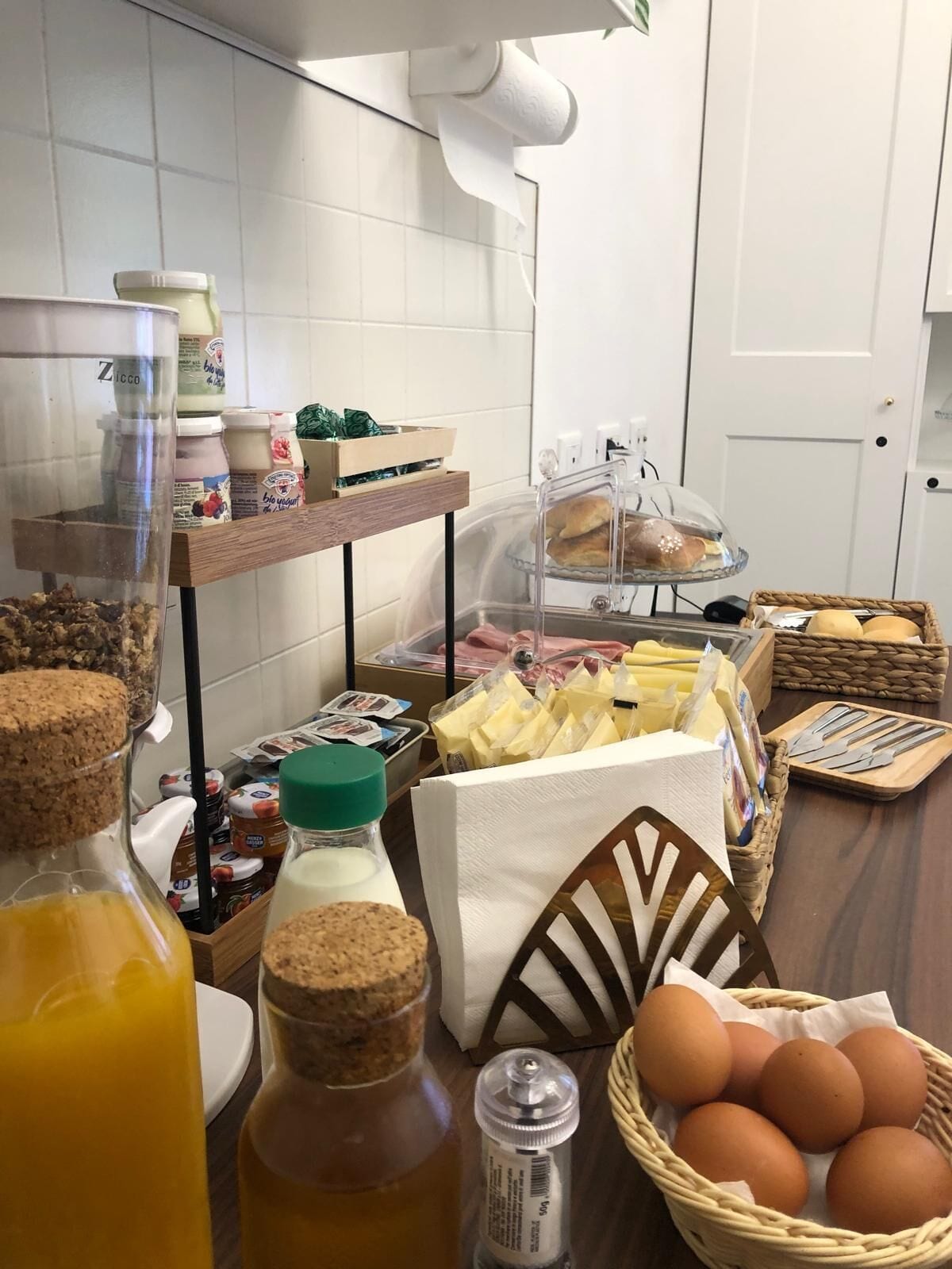A breakfast buffet setup with various food items and condiments.