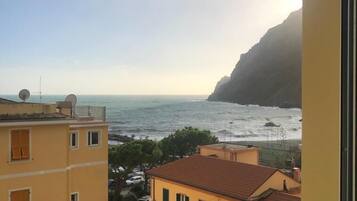 Une vue sur la côte depuis un balcon, avec des bâtiments au premier plan et une falaise rocheuse en arrière-plan.