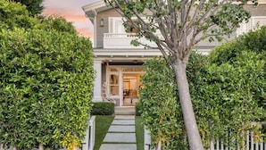 A two-story house with a front porch, a pathway leading to the entrance, and a tree in the center. - Stunning 5bdr Minutes to Beach, Pier, Restaurants Emerald Cove by Avantstay (Newport Beach)