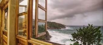 Private wooden villa with stunning ocean views, in an enchanting garden setting.