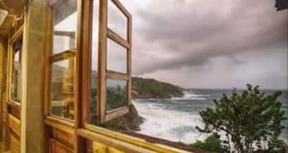 Private wooden villa with stunning ocean views, in an enchanting garden setting.