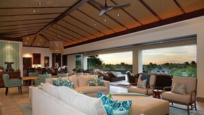 Un amplio espacio habitable con un sofá grande, una mesa de comedor y vistas al exterior.