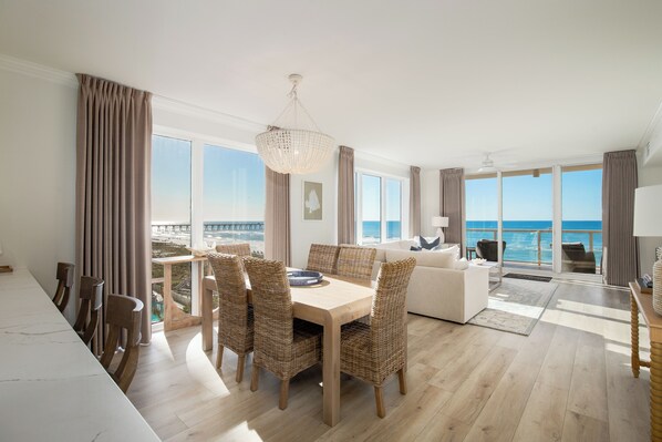 Enjoy a meal at the dining table surrounded by wicker chairs with a view of the sea and pier.