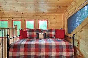 Cozy loft bedroom with one queen bed and one queen daybed, comfortably sleeping up to four guests. This inviting open space is perfect for families, friends, or additional guests to relax and recharge.