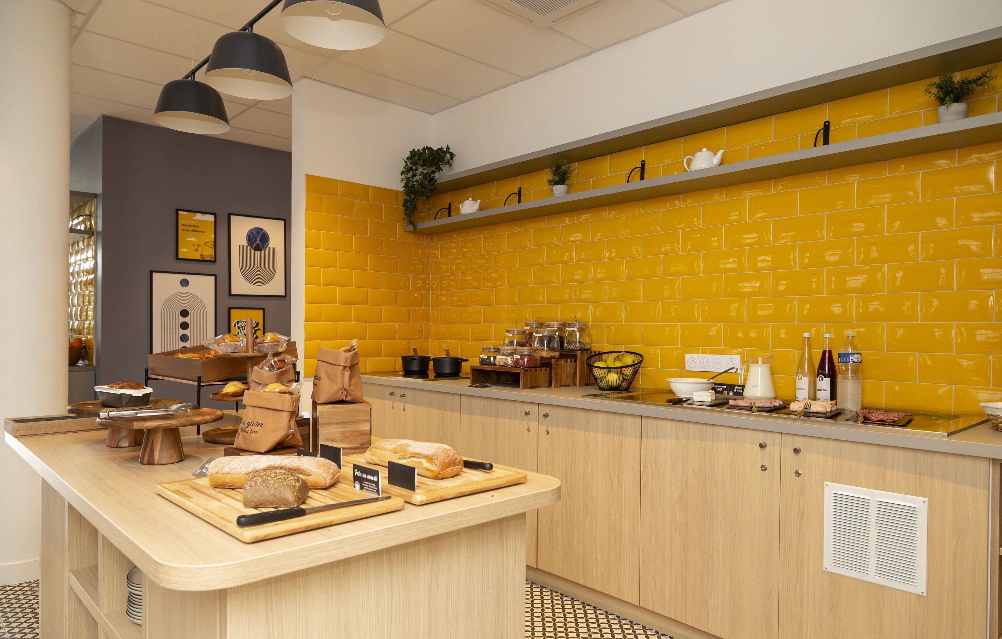 Een keuken met een houten aanrecht, een achterwand van gele bakstenen en diverse keukenapparatuur en keukengerei.