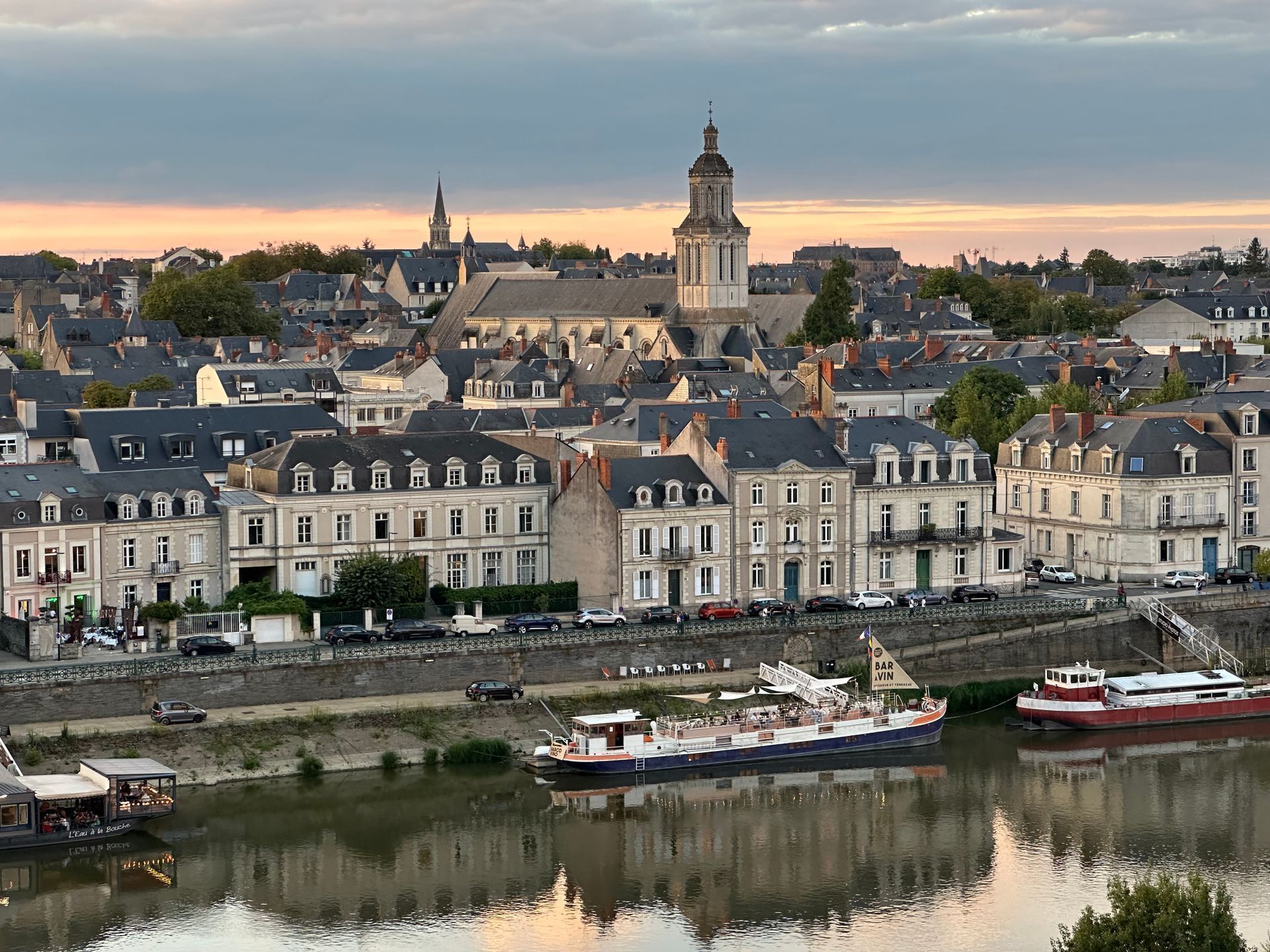 Une rivière avec des bateaux, un pont et des bâtiments le long de la rive.
