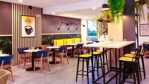 Ein modernes Café mit gestreiftem Mauerwerk, einer zentralen Bar und verschiedenen Sitzgelegenheiten, darunter Barhocker und Stühle.
